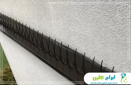 تركيب شبك طارد الحمام في جدة 0550234190 ابراج كلين تُظهر الصورة طارد حمام بتصميم عصري يمتلك قاعدة بلاستيكية سوداء عريضة، مثبتة على طول حافة جدار