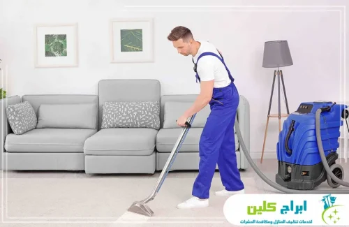 شركة تنظيف منازل بجازان 0550234190 شركة أبراج كلين عامل تنظيف من ابراج كلين ينظف غرفة معيشة بالمكنسة مع عناية بالأرضيات لخدمة تنظيف منزلية دقيقة.