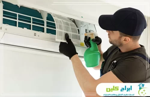 فني ينظف فلاتر المكيف السبليت ويزيل الغبار لتحسين تدفق الهواء وكفاءة التبريد.