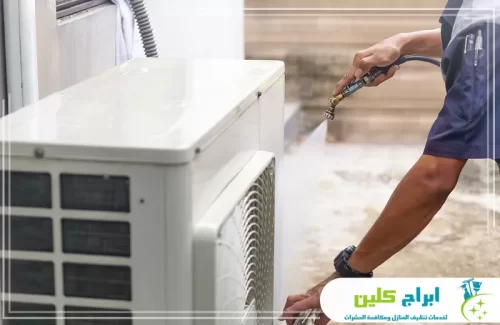 تنظيف الوحدة الخارجية للمكيف في بصامطة بالماء المضغوط لإزالة الغبار وتحسين كفاءة التبريد.