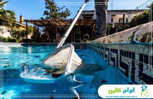 تنظيف أرضية المسبح في بصامطة باستخدام شبكة التقاط الشوائب لضمان صفاء المياه بسرعة.